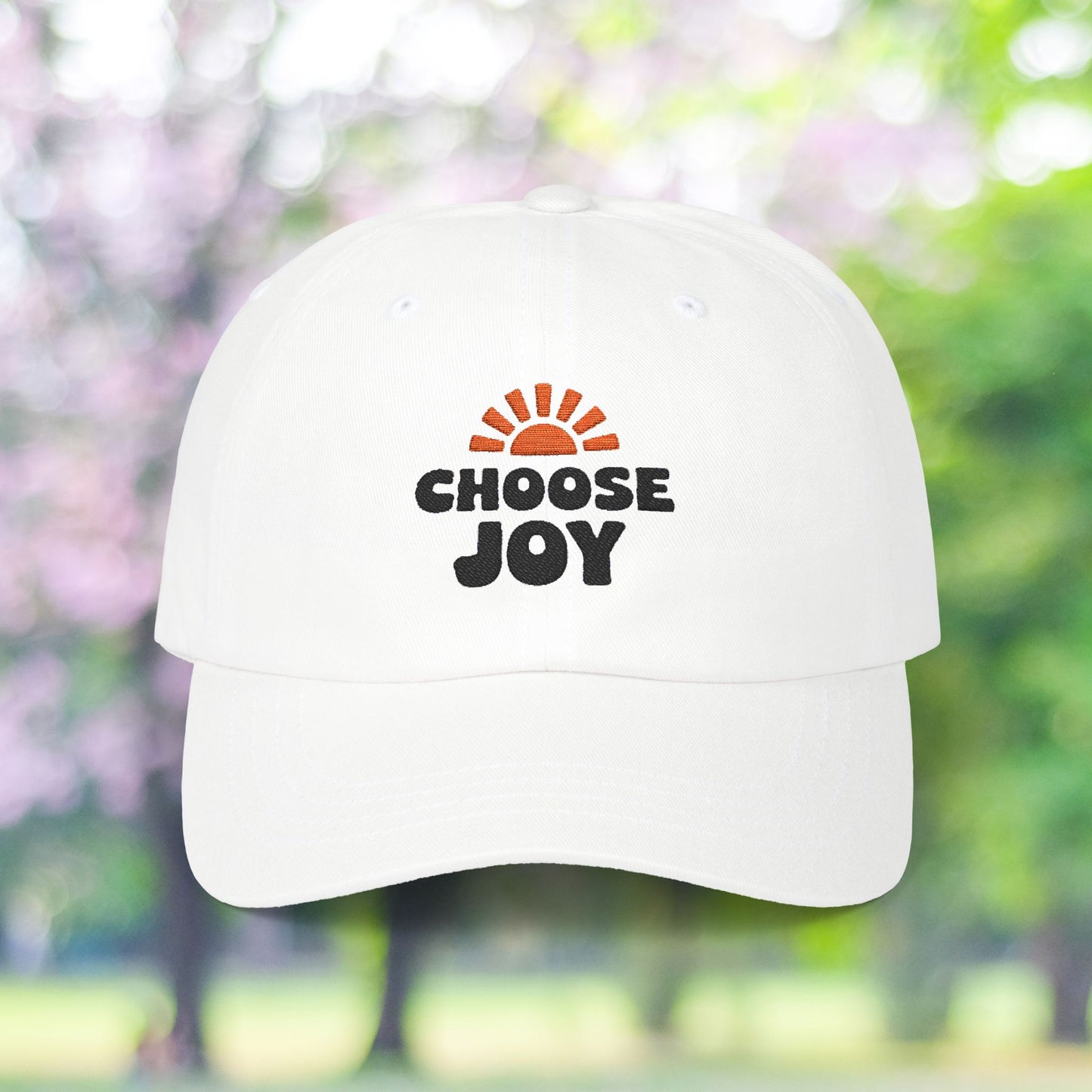 White baseball cap with 'Choose Joy' sun burst graphic.