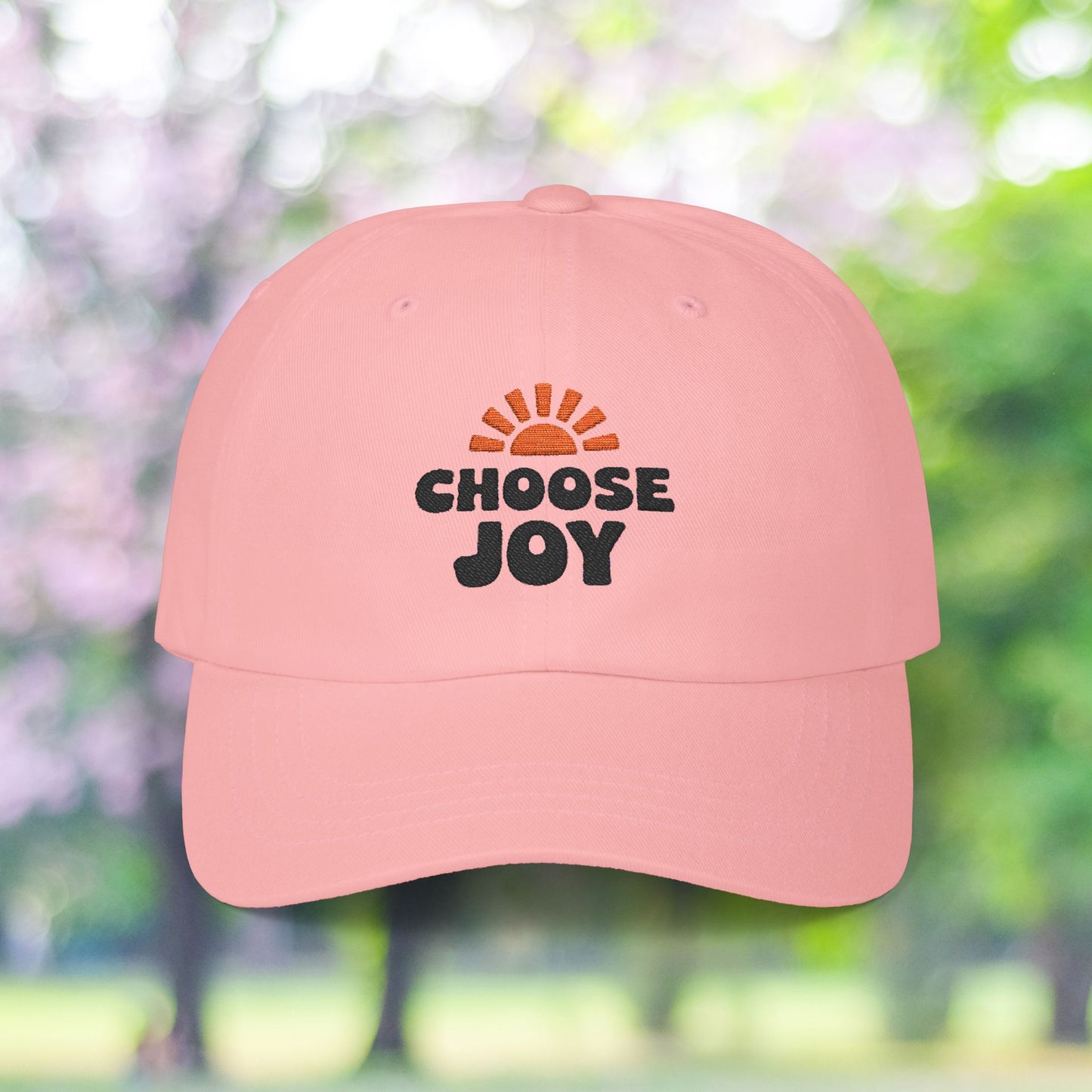 Pink baseball cap with "Choose Joy" and sun burst graphic