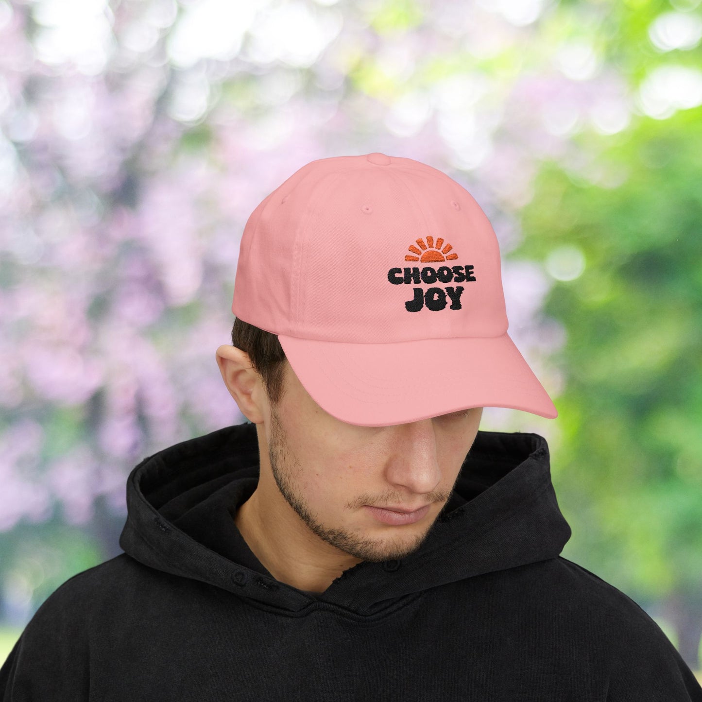 Pink baseball cap with Choose Joy graphic, sun burst design.